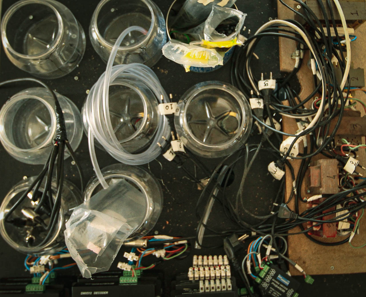 Overhead view of the control room: fluid jars, tubing, and DMX decoders wired up backstage.