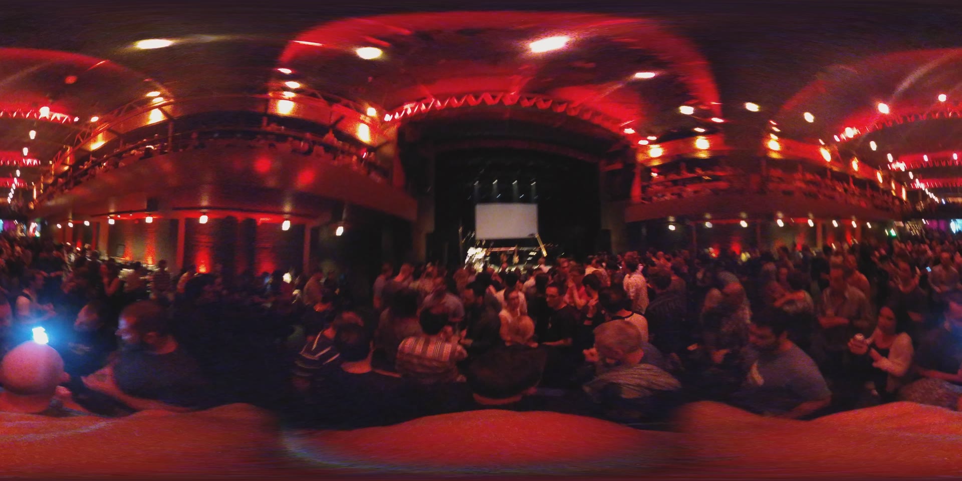 Ornate red theatre balconies, packed with the crowd